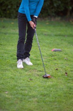 Yeşil bir golf sahasında şoförle golf oynayan kadın golfçü spor ve eğlence aktivitelerinden zevk alıyor.