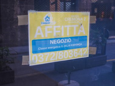 Cremona, İtalya 13 Ağustos 2025. Dükkan vitrinine yapıştırılmış sarı kiralama tabelası, Cremona, Lombardy 'deki kontak detaylarını ve enerji seviyesini gösteriyor.