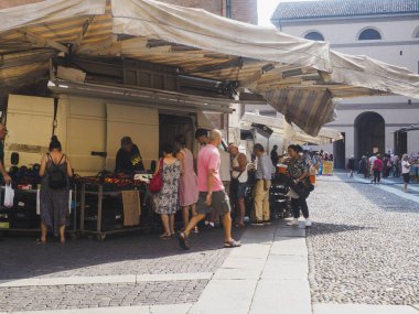 Cremona, İtalya 13 Ağustos 2025 Turistler ve yerel halk taze ürün ve yerel ürünler için Cremona, İtalya 'da canlı bir açık hava pazarında otantik İtalyan kültürünün tadını çıkarıyorlar.