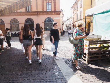 Cremona, İtalya 'da 13 Ağustos 2025. Turistler ve yerliler güneşli bir yaz gününde Cremona, Lombardy, İtalya' da bir çiftçi pazarında yürüyüş ve alışveriş yapıyorlar.