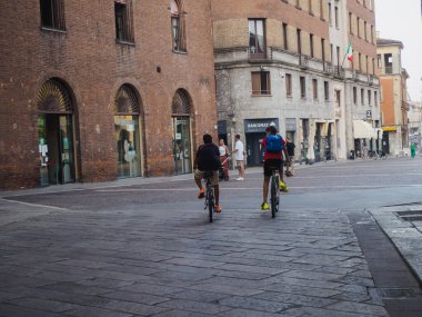 Cremona, İtalya 13 Ağustos 2025 Günışığı Cremona Meydanı 'nda pedal çeviren bisikletçiler sıcak öğleden sonra kentsel eğlence sahnesini çerçeveleyen tarihi mimari