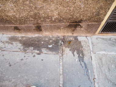 Cremona, İtalya 13 Ağustos 2025. Kirli su kaldırımda paslı bir ızgaranın yanında duruyor. Cremona, Lombardy, İtalya 'da ihmal ve kentsel bozulma belirtileri gösteriyor.