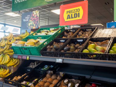 Cremona, İtalya 11 Ağustos 2025. Muz, avokado, mango, zencefil ve hindistan cevizi içeren renkli ürünler. Yerel bir ALDI süpermarketinin raflarını dolduruyor.