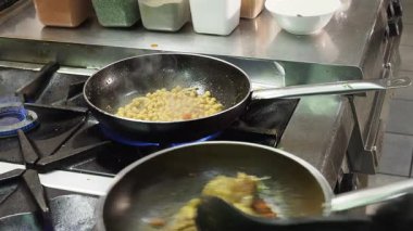 Profesyonel şef titizlikle otantik Hint mutfağını hazırlıyor, tavuk parçalarını nohut ve aromatik baharatlarla dolu tavuğa dikkatlice ekliyor.