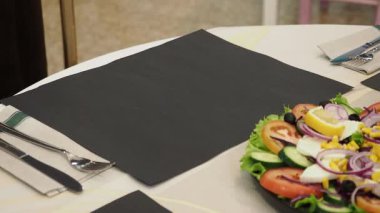 Profesyonel garson eldivenli profesyonel olarak gurme Hint mutfağı tabağı sunuyor zarif restoran yemek masasında taze salata ve el değmemiş beyaz masa örtüsü.