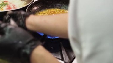 Profesyonel aşçı Tadka 'yı hazırlıyor, baharat ve diğer malzemelerin karışımı, yağ ve ghee' de ısıtılıyor, Hint mutfağında lezzet katmak için kullanılıyor.