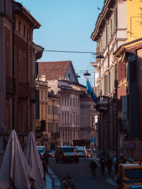 Cremona, İtalya 27 Eylül 2025 İtalya Cremona, İtalya 'da güneş ışığı altında tarihi cephelerle, balkonlarla, yayalarla, bisikletçilerle ve hareket halindeki bir minibüsle dolu.