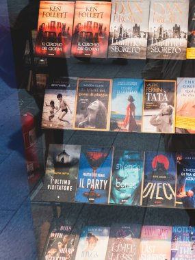 Cremona, İtalya 'da 27 Eylül 2025' te Cremona 'daki açık İtalyan kitapçısında Follett ve Brown gibi uluslararası yazarların renkli kapakları sergilendi.
