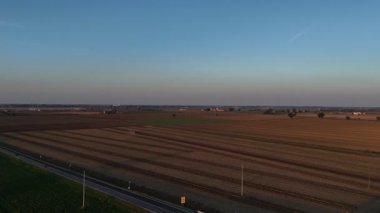 Alacakaranlıkta ufka uzanan Po Valley arazileri, sulama kanalının yanındaki yeni yolları birleştiren modern döner kavşak, sürdürülebilir tarım ve kırsal altyapı gelişimi sergiliyor, yavaş