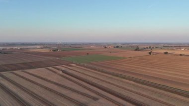 Po Vadisi tarım arazisi geniş tarlalar, çeşitli ekinler ve yaz akşamları arazi yetiştiren bir traktör gösteriyor. Modern tarım tekniklerini ve kırsal İtalya 'yı vurguluyor.