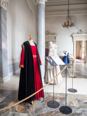 Cremona, Italy November 19th 2025 Exhibition displaying several medieval Sforza court noble costumes on mannequins, including a red dress with a long black cloak
