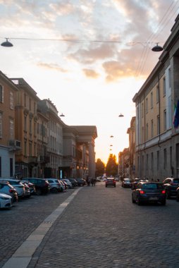 Cremona, İtalya - 21 Ekim 2025 Günbatımı Cremona Lombardy İtalya 'daki Teatro Amilcare Ponchielli' ye giden tarihi sokağa sıcak altın ışık tutuyor.