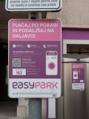 Sezana, Slovenya - 22 Kasım 2025 EasyPark tabelasında mobil park ödeme çözümleri, uygulama indirme için bir QR kodu ve Slovence uygun dijital park talimatları gösteriliyor