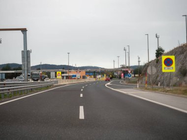 Sezana, Slovenya - 22 Kasım 2025 Slovenya 'dan İtalya' ya uluslararası sınırı geçmek, gri gökyüzü altındaki kontrol kabinleri ve yol işaretlerinden geçmek, Avrupa seyahatini ve açık