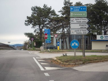 Trieste, İtalya - 21 Kasım 2025 Sınır kapısı yakınlarındaki bir sınır kapısı kavşağını gösteren sınır denetimi, gümrük ve kasabaların yönlerini gösteren işaretler