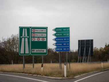 Trieste, İtalya - 21 Kasım 2025 İtalya sınırından Udine, Venezia ve Gorizia şehirlerine giden yol ve yolları gösteren çoklu yeşil ve mavi yol işaretleri
