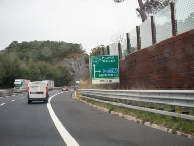 Friuli, İtalya 21 Kasım 2025 A4 otoyolu üzerinde seyahat eden araçlar, Milano, Venezia ve Gorizia noktalarını gösteren bir işareti geçerek,