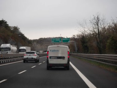 Friuli, İtalya 21 Kasım 2025 Monfalcone, İtalya yakınlarındaki A4 otoyolu üzerindeki araçlar, yoğun otoyol üzerindeki bulutlu bir gündüz gökyüzünün altındaki şeritler boyunca ilerliyorlar.