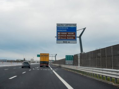 Friuli, İtalya 21 Kasım 2025 Latisana çıkış tabelasına doğru giden A4 İtalyan otoyolunda Codroipo, Lignano Bibione, Villa Manin bulutlu gökyüzünün altında