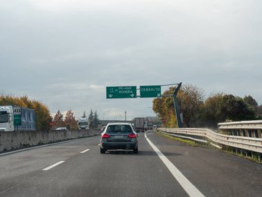 Friuli, İtalya 21 Kasım 2025 Milano ve Venezia 'ya doğru İtalyan A4 otomobili sürüyor, yön işaretleri, bulutlu sonbahar gökyüzü ve bulanık trafik hareketi