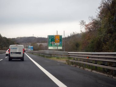 Friuli, İtalya 21 Kasım 2025 Friuli Bölgesi 'nde bir İtalyan otoyolunda, beyaz bir minibüs Monfalcone Est' in yeşil çıkış işaretini geçtikten sonra