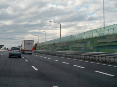 Venedik, İtalya 21 Kasım 2025 Otoyolda seyahat eden araçlar, Serenissima otoyolu, çevreyi koruyan görünür bir ses duvarı ile