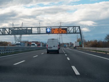 Venedik, İtalya 21 Kasım 2025 Kuzey İtalya 'da Autostrada A4' te giden araçlar, kış lastiği veya zincir zorunluluğu bildiren değişken bir mesaj levhası altında geçmektedirler.