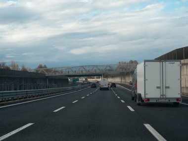 Venedik, İtalya 21 Kasım 2025 Kuzey İtalya 'da bulutlu bir günde yaya köprüsünün altından geçen araba ve kamyonlarla dolu çoklu şeritli otostrada