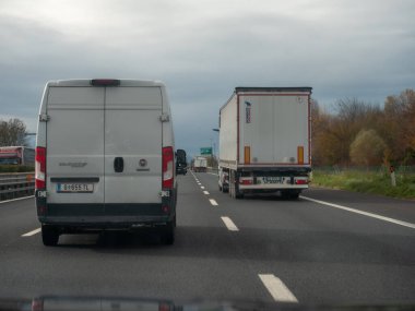 Venedik, İtalya 21 Kasım 2025 Beyaz bir minibüs ve büyük bir kamyon dahil olmak üzere, A4 Serenissima otoyolunda ilerliyor, karayolu taşımacılığı ve lojistik