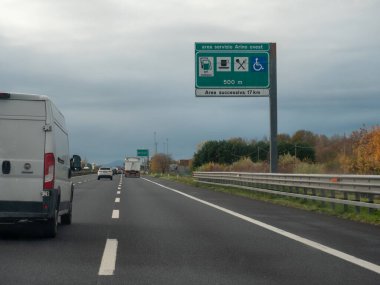 Venedik, İtalya 21 Kasım 2025 Otoyol trafiği Autostrada A4, Arino Ovest 'e yakıt ikmali, gıda ve ulaşılabilirlik ile hizmet alanı tabelası