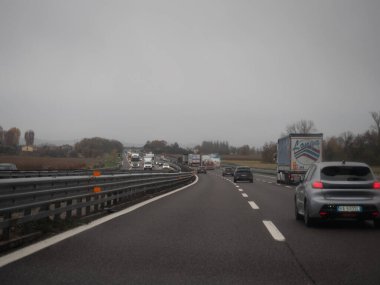 Venedik, İtalya 21 Kasım 2025 İtalyan Autostrada A4 bulutlu gökyüzü, banliyö ve taşımacılık rötar altında ağır trafikte araç ve kamyonlarla dolup taştı