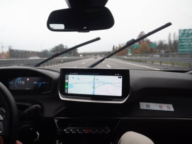 Venedik, İtalya 21 Kasım 2025 Araç iç perspektifi Autostrada A4, Serenissima otoyolunda yağmur sırasında bir navigasyon sistemi ekranını gösteriyor