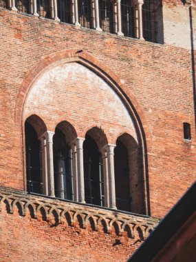 Cremona, İtalya 3 Ekim 2025 Torrazzo çan kulesi tarihi Avrupa mimarisini yansıtan dekoratif tuğla, kemerli pencere ve sütunların detaylarını gösteriyor