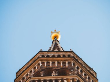 Cremona, İtalya 3 Ekim 2025 Torrazzo çan kulesinin altın kaplama ve küre ile süslenmiş üst kulesi Cremona, İtalya üzerinde açık mavi bir gökyüzüne karşı yükseliyor