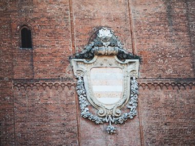 Cremona, İtalya 3 Ekim 2025 Torrazzo çan kulesi tarihi tuğla işçiliği, bir arma ve İtalyan mirasını temsil eden gotik bir pencere gösteriyor.