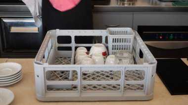 Cremona, İtalya - 19 Temmuz 2025 Restoran ve konukseverlik bulaşık takımı ve bardakların verimli ve güvenli bir şekilde temizlenmesi için tasarlanmış ticari bulaşık makinesi rafları ve sepetleri yoğun mutfak ortamlarında organize kurutma ve depolamayı kolaylaştırıyor