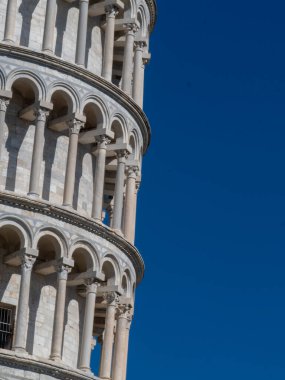 Pisa, Toskana - 16 Ekim 2025 Iconic Leaning Tower of Pisa mimari tarihi Piazza dei Miracoli 'de güneşli bir günde açık mavi bir gökyüzünün altında dimdik ayakta duruyor