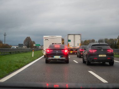 Brescia, İtalya 21 Kasım 2025 Lombardiya 'da A21 karayolunda trafik sıkışıklığı. Yağmurlu ve yavaş hareket eden koşullarda gri gökyüzünün altında araçlar ıslak asfaltta kuyruk oluşturdu.