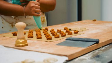 Eller taze el yapımı makarna hazırlıyor, çiğ kareli ravioli ya da pierogi dikkatlice konuyor, geleneksel yemek pişirme sürecini ve ev yapımı yemekleri gösteriyor.