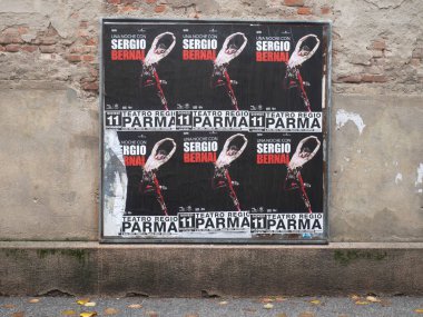 Cremona, İtalya - 21 Ekim 2025 Çok sayıda soluk ve yırtık sokak posterleri tarihi Cremona İtalya 'da yıpranmış bir kent duvarında bir etkinliğin reklamını yapıyor