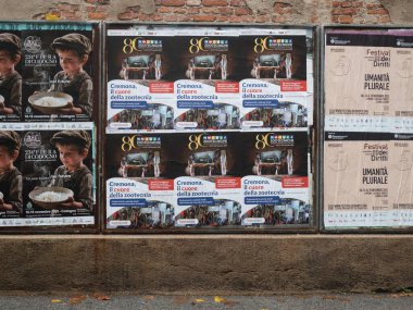 Cremona, İtalya - 21 Ekim 2025 Yıpranmış reklam afişleri, Cremona İtalya 'nın tarihi Cremona kentsel duvarında kamuya açık mesajlaşma ve kentsel çürüme içeren dokulu bir kent duvarını kaplıyor