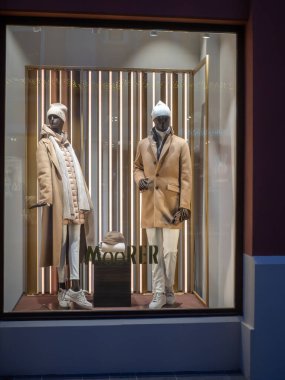 Fidenza, İtalya 6 Aralık 2025 Mankenleri lüks moda butik vitrininde şık Mağribi kışlık ceketleri ve aksesuarlarını Noel tatili boyunca sergiliyorlar.