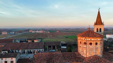 Crespiatica 'daki Kutsal Merhamet Bakiresi Mabedi. Lombardiya. İtalya. Havadan bakıldığında tarihi dini mimari sergileniyor. Campanile. Kırsal alan. Saha. Gün batımı ışığı