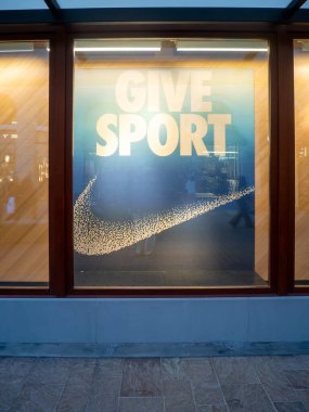 Fidenza, İtalya 5 Aralık 2025 Nike mağazasının yaratıcı vitrininde spor metinleri ve ikonik swoosh verin, tatil sezonunda Noel hediyesi fikirlerini destekleyin
