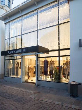 Fidenza, İtalya 5 Aralık 2025 Flavio Castellani moda butiği vitrininde Noel sezonu boyunca lüks kıyafetler ve aksesuarlar sergileniyor.