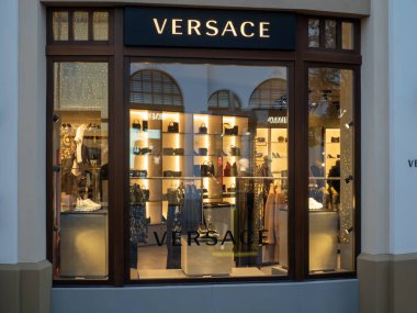 Fidenza, İtalya 5 Aralık 2025 Versace mağazasının vitrininde tasarım el çantaları, ayakkabılar ve giysiler satışa sunuluyor ve üst düzey alışveriş deneyimleriyle ilgilenen müşterileri cezbediyor.