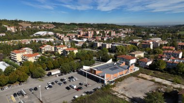 Salsomaggiore Terme, İtalya 1 Aralık 2025 Salsomaggiore Terme, İtalya. Otoparkı, yolları ve konutları olan bir süpermarketin yer aldığı havadan şehir manzarası.
