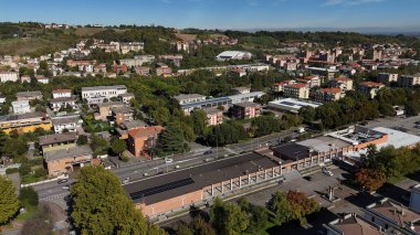 Salsomaggiore Terme, İtalya 1 Aralık 2025 Salsomaggiore Terminali, güneş panelleri, yollar, ağaçlar ve uzak tepelerle konut ve ticari çatıları gösteren şehir manzarası