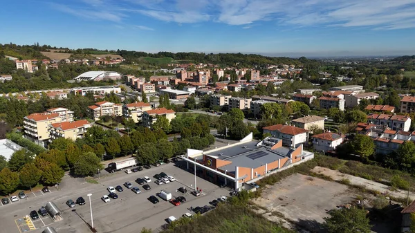 Salsomaggiore Terme, İtalya 1 Aralık 2025 Salsomaggiore Terme, İtalya. Otoparkı, yolları ve konutları olan bir süpermarketin yer aldığı havadan şehir manzarası.