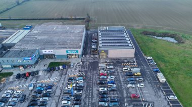 Vescovato, İtalya 7 Aralık 2025 Pepco, Action, Tigota mağazaları ve MD süpermarketleri ile büyük bir otoparkın yer aldığı hareketli bir ticari perakende parkı sergiliyor.